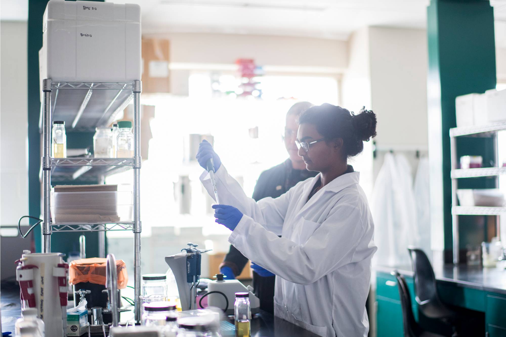 A cell and molecular biology student in a GVSU lab working with her professor.